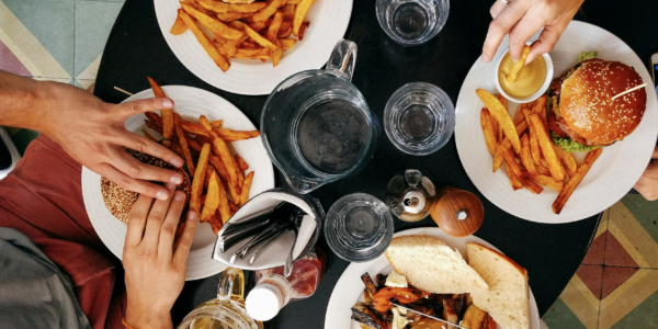 Blick auf einen Tisch, an dem mehrere Personen zusammen speisen