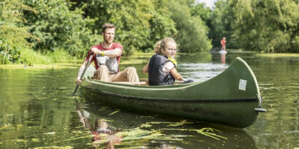 Ein Mann und ein Mädchen fahren mit einem Kanu auf einem Fluss in Niedersachsen