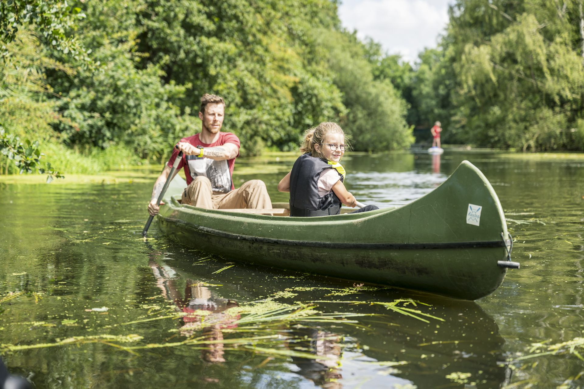 Ein Mann und ein Mädchen fahren mit einem Kanu auf einem Fluss in Niedersachsen